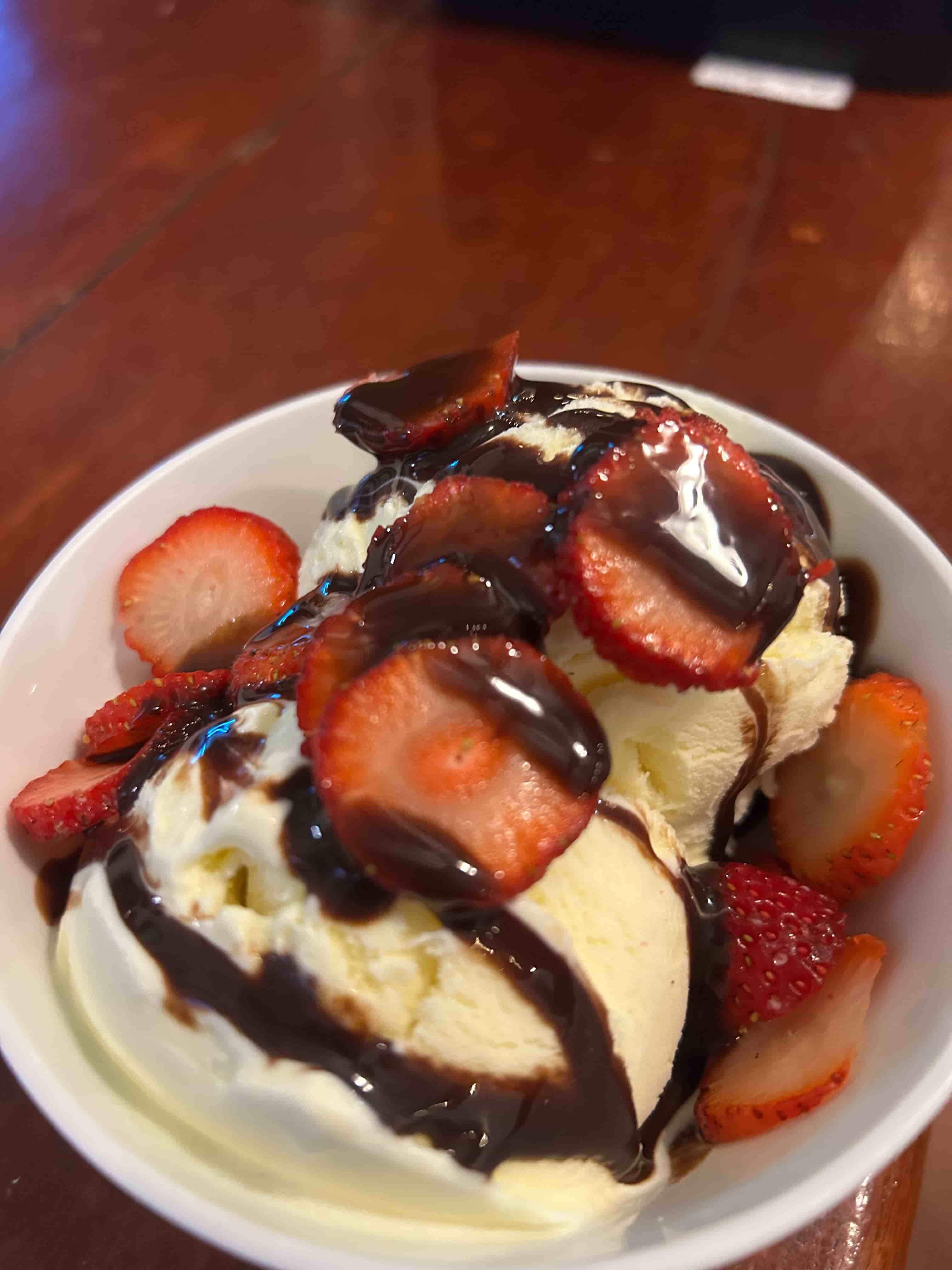 Postre de helado con fresas y chocolate